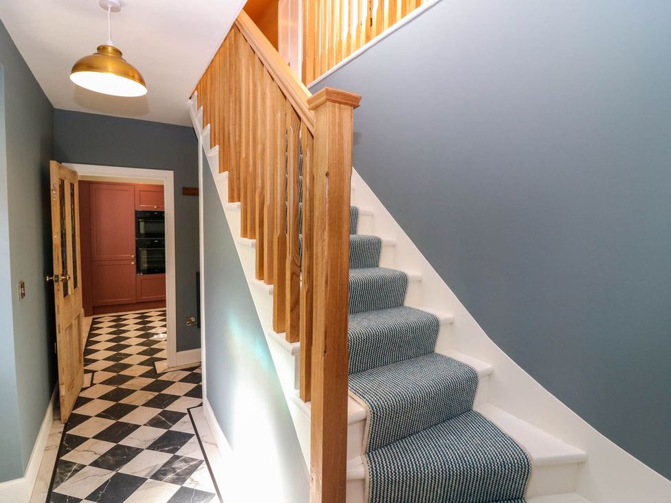 A hallway with a staircase and door at Evansford in Ballater