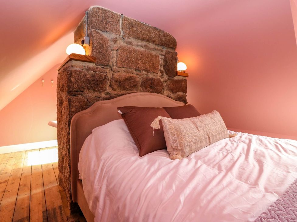 A bedroom with a bed against a stone wall at Evansford in Ballater