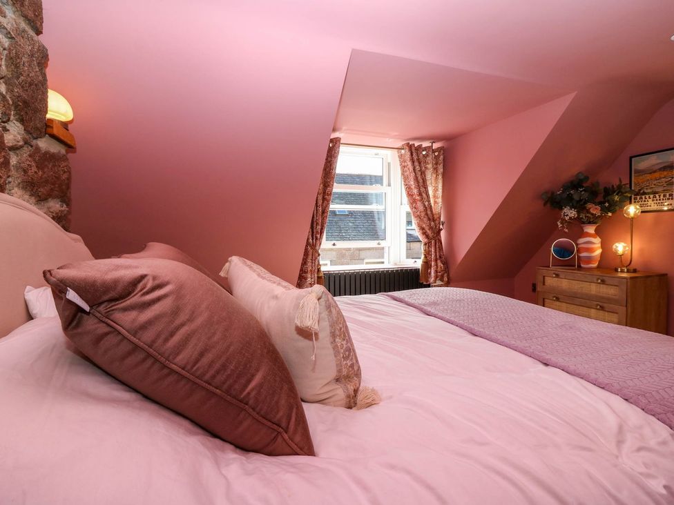 A bedroom with a bed and window at Evansford in Ballater