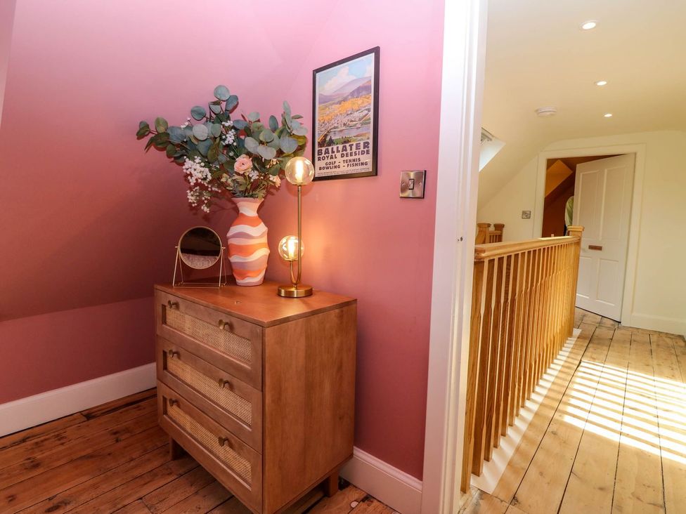 A hallway with a dresser and flowers at Evansford in Ballater