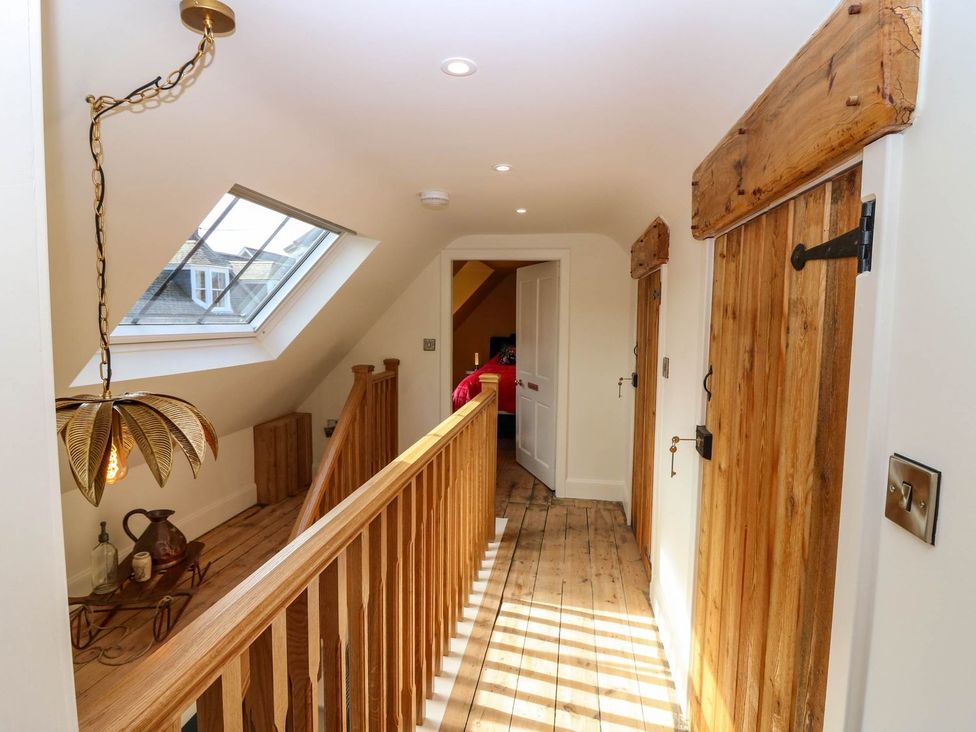 A hallway with a staircase and wooden doors at Evansford in Ballater