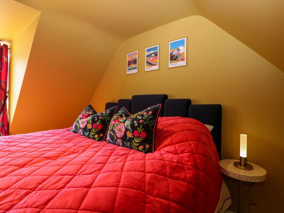 A bedroom featuring a bed with pillows and lamp at Evansford in Ballater