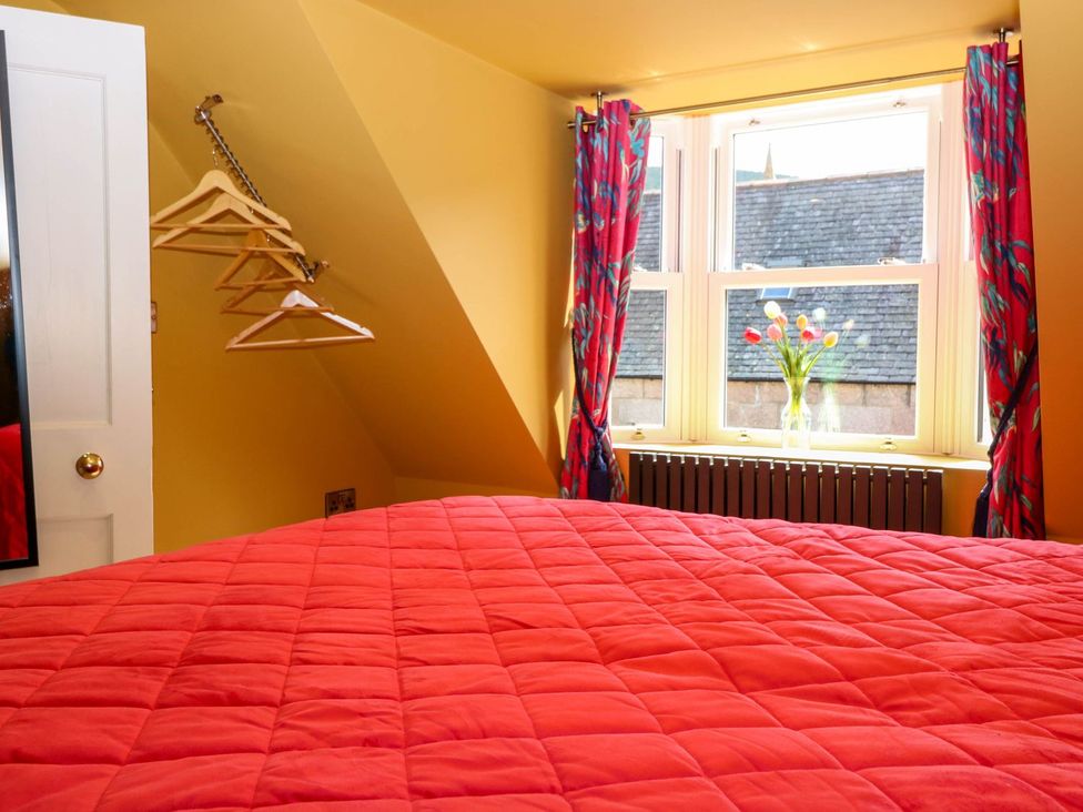 A bedroom with a bed and window at Evansford in Ballater