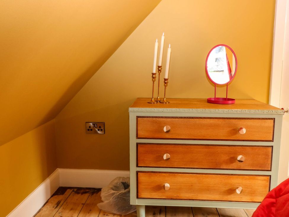 A dresser with candles and a mirror in a bedroom at Evansford Ballater