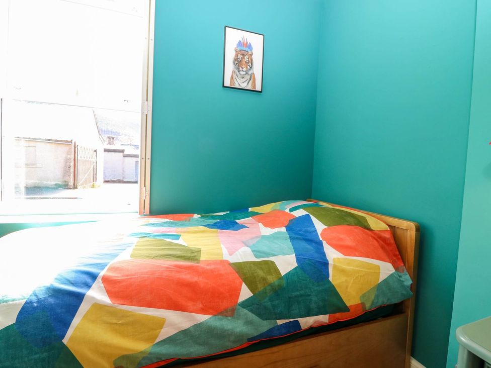 A bedroom with a bed and colorful bedding at Evansford in Ballater
