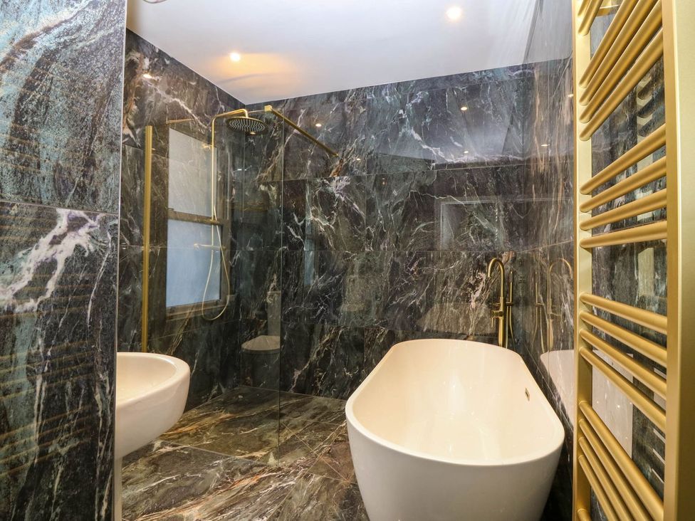 A bathroom with a bathtub and shower at Evansford in Ballater