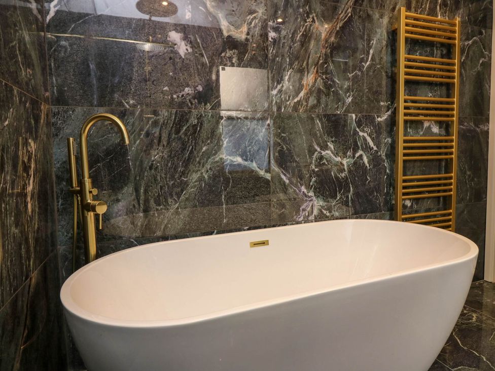 A bathroom with a bathtub and a towel warmer at Evansford in Ballater