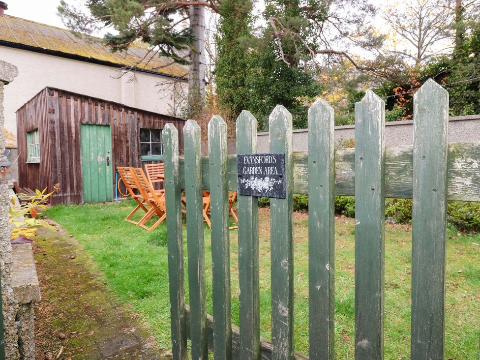 A garden area with a wooden shed and seating at Evansford in Ballater