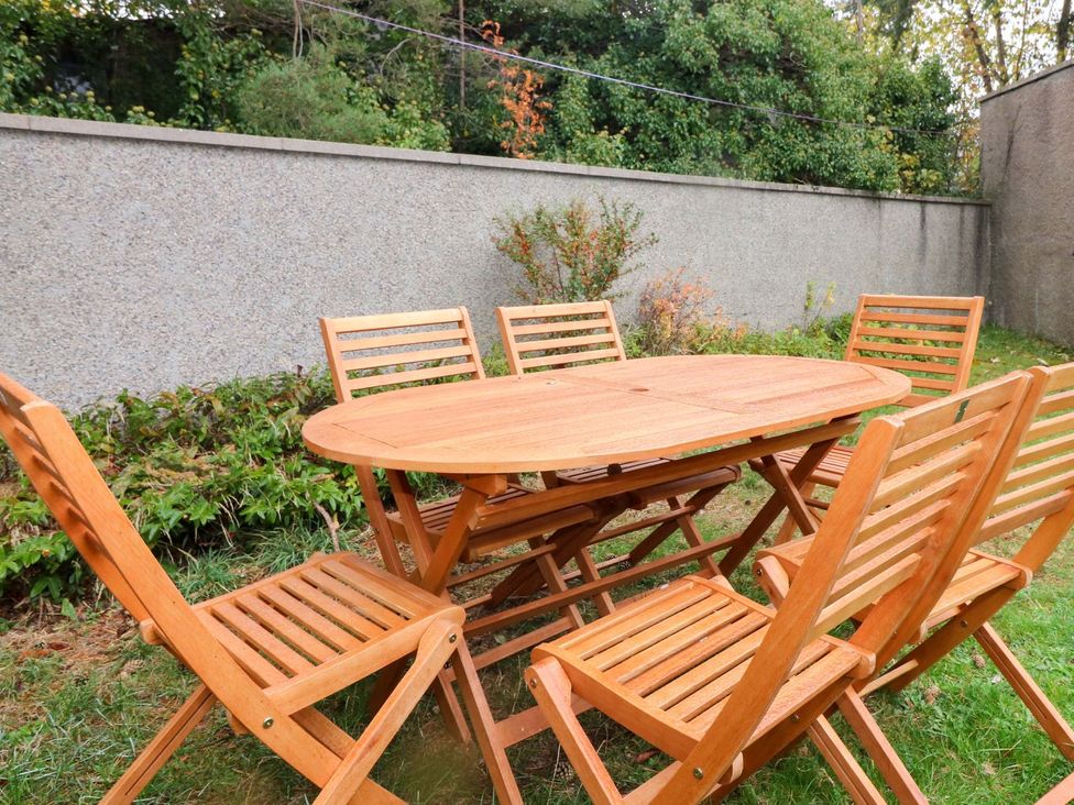 A wooden table with chairs in a garden at Evansford in Ballater