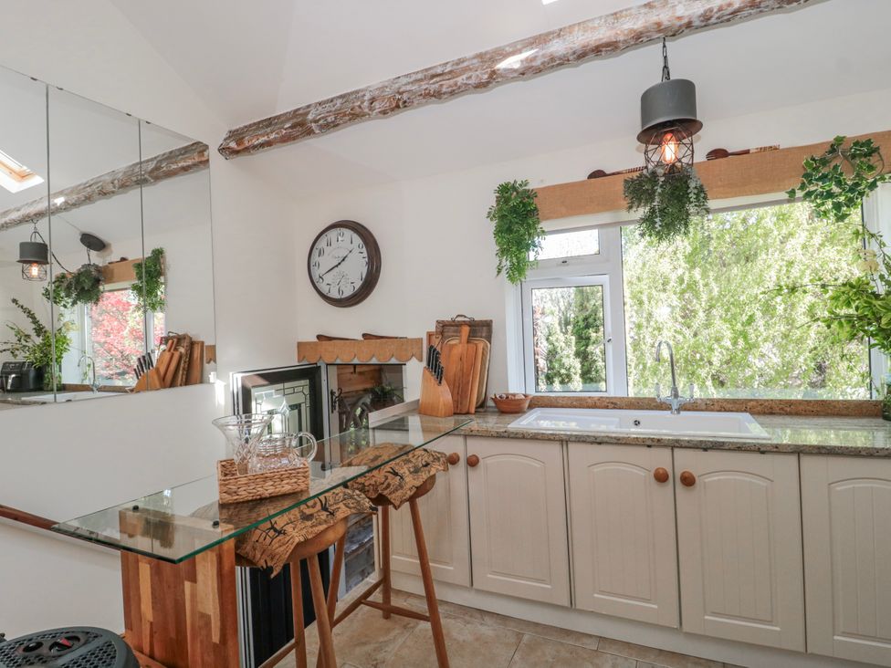 A kitchen with a sink, countertop, and clock at 7 The Cedars, Wotton-Under-Edge
