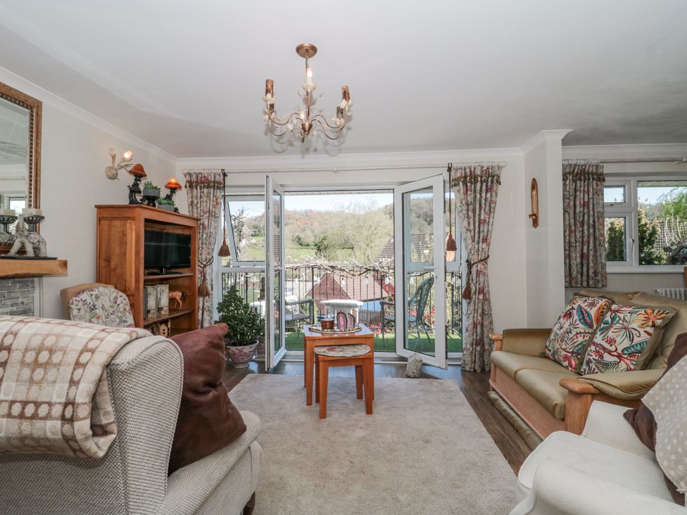 A living room with a sofa, chair, and coffee table at 7 The Cedars in Wotton-Under-Edge