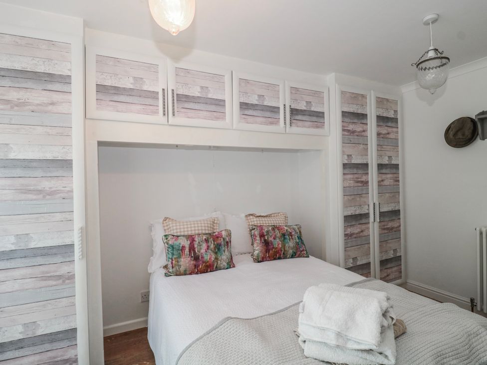 A bedroom with a bed and wardrobe at 7 The Cedars in Wotton-Under-Edge