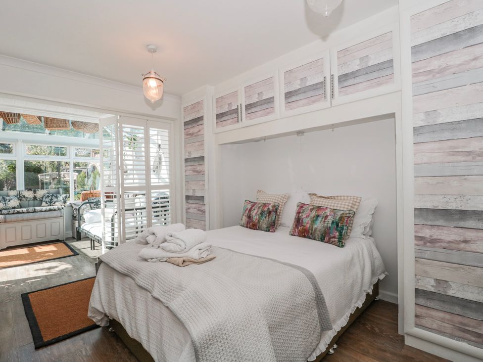 A bedroom with a bed and wall cabinetry at 7 The Cedars in Wotton-Under-Edge