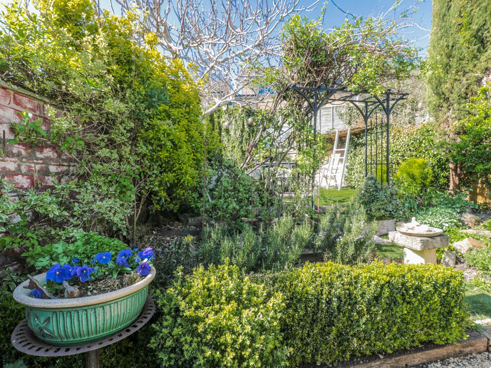 A garden featuring a birdbath and an archway at 7 The Cedars in Wotton-Under-Edge
