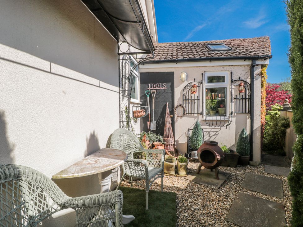 A garden with gravel path and seating area at 7 The Cedars Wotton-Under-Edge