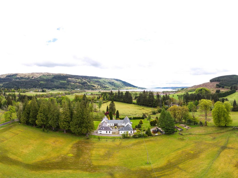 An aerial view of a house surrounded by trees and fields at Argyll Farmhouse-Idyllic Setting-Sleeps10 in Dunoon