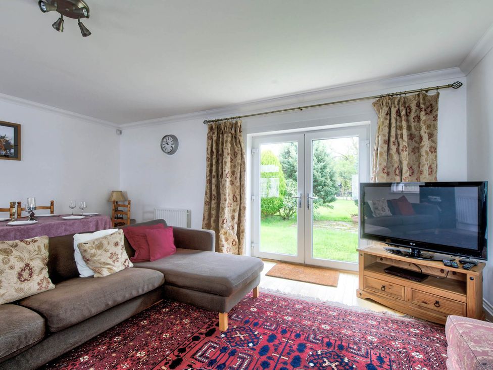 A living room with a sofa and television at Argyll Farmhouse-Idyllic Setting-Sleeps10 in Dunoon