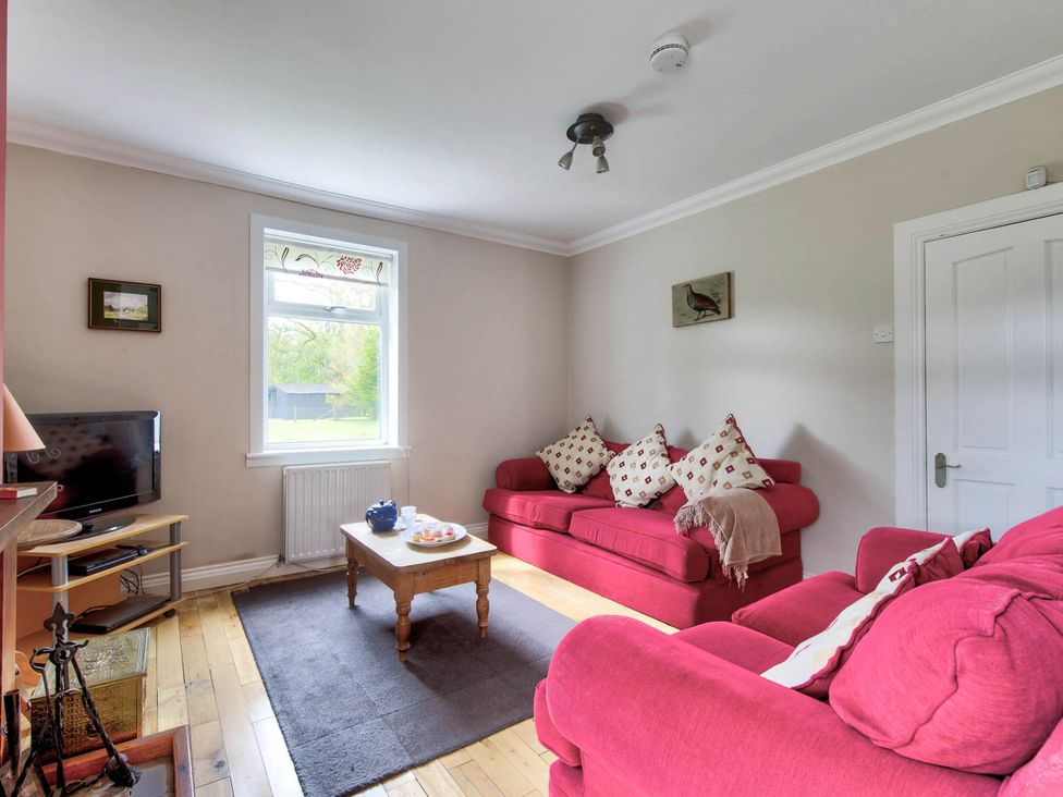 A living room with a sofa and television at Argyll Farmhouse-Idyllic Setting-Sleeps10 in Dunoon