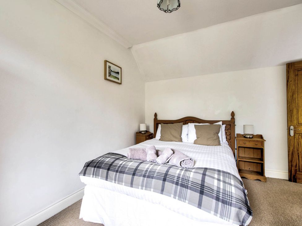 A bedroom with a bed and bedside tables at Argyll Farmhouse-Idyllic Setting-Sleeps10, Dunoon