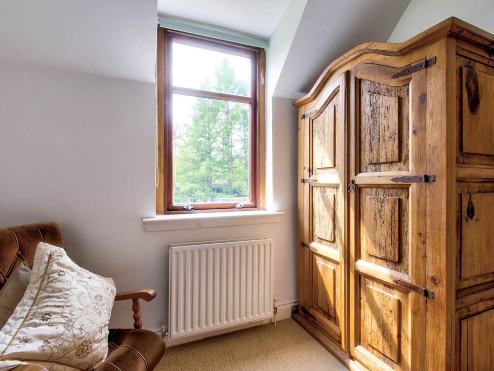 A bedroom with a window and wooden wardrobe at Argyll Farmhouse-Idyllic Setting-Sleeps10, Dunoon