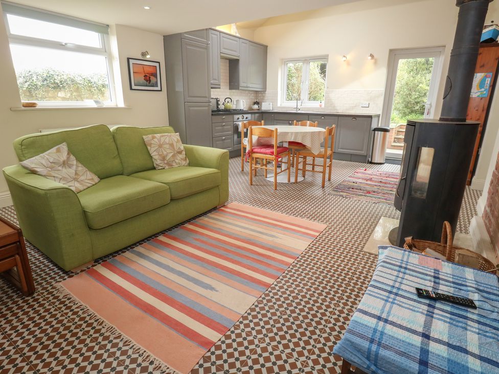 A living room with a sofa and dining area at Millmead House Annex Portesham