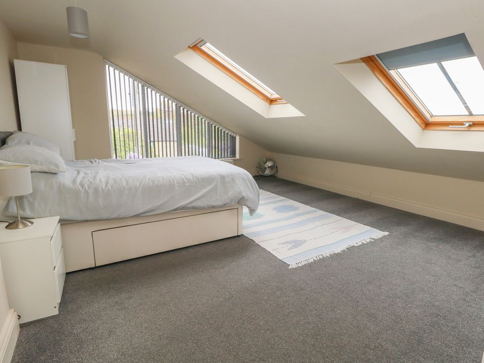 A bedroom with a bed and windows at Millmead House Annex Portesham