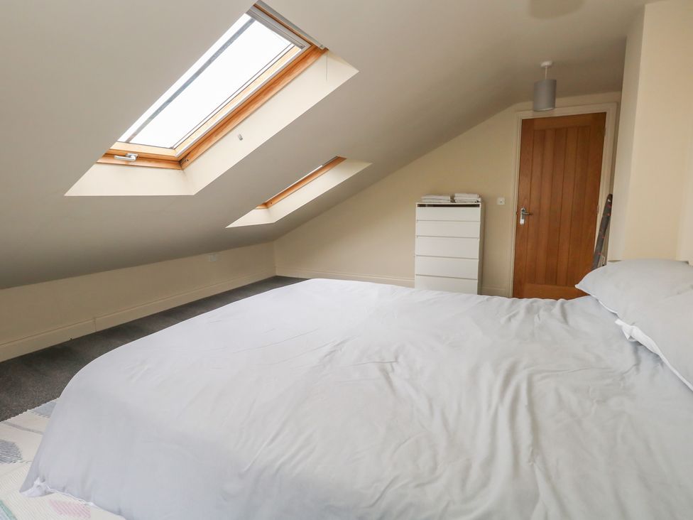 A bedroom with a bed and windows at Millmead House Annex Portesham