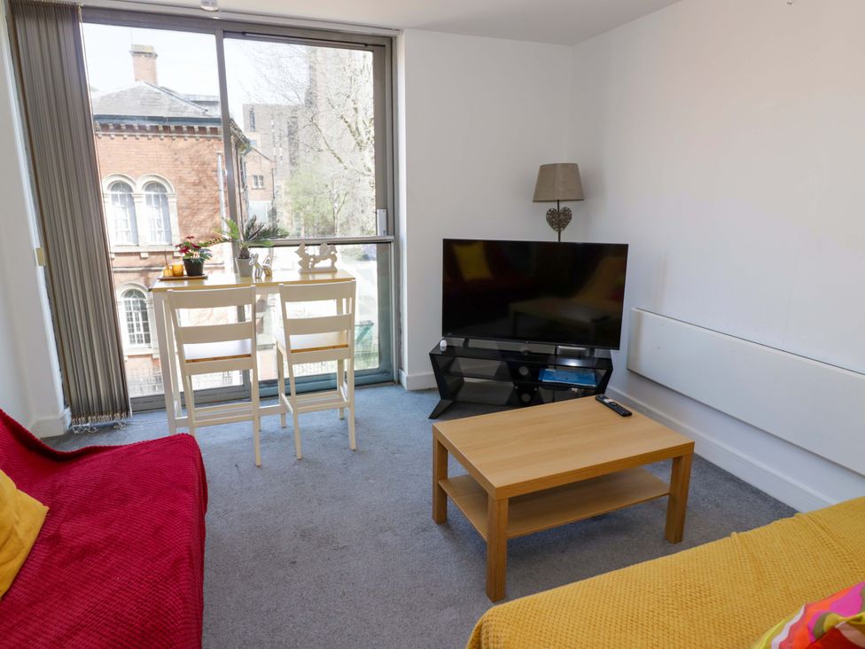 A living room with a table and chairs at Apartment 26 in Birmingham