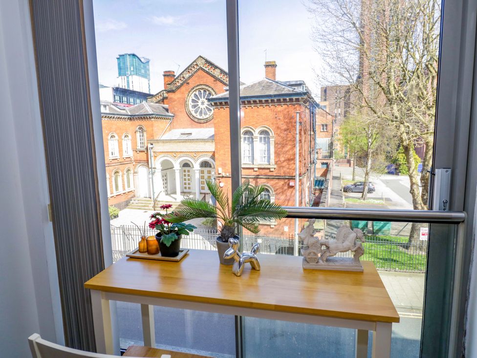 A table with a plant and sculpture in front of a window at Apartment 26 in Birmingham