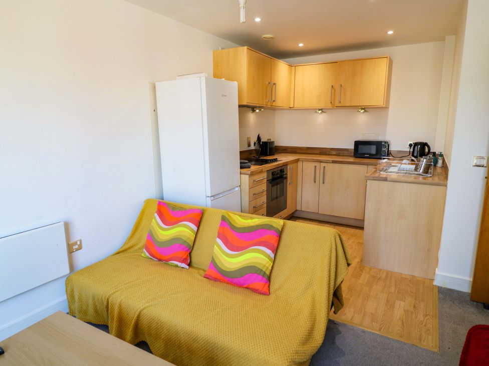 A kitchen with appliances and a sofa at Apartment 26 in Birmingham