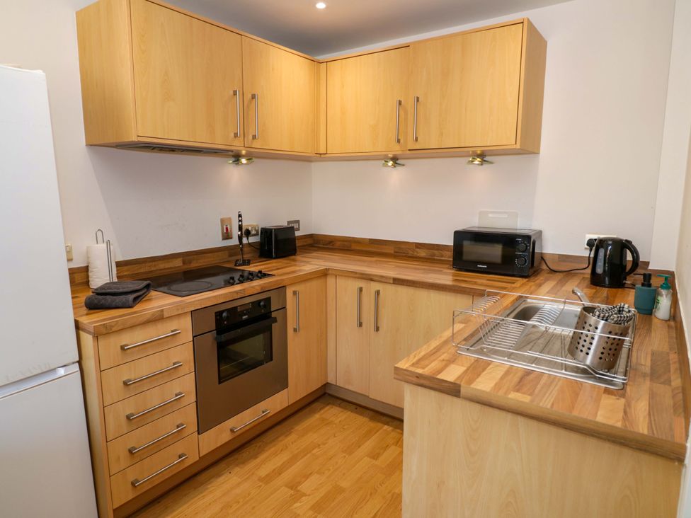A kitchen with cabinets, stove, sink, and microwave at Apartment 26, Birmingham