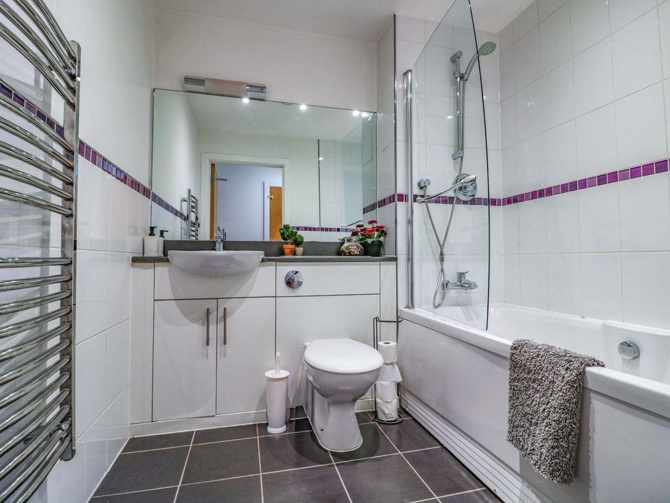 A bathroom with bathtub, toilet, sink, and towel rack at Apartment 26 in Birmingham