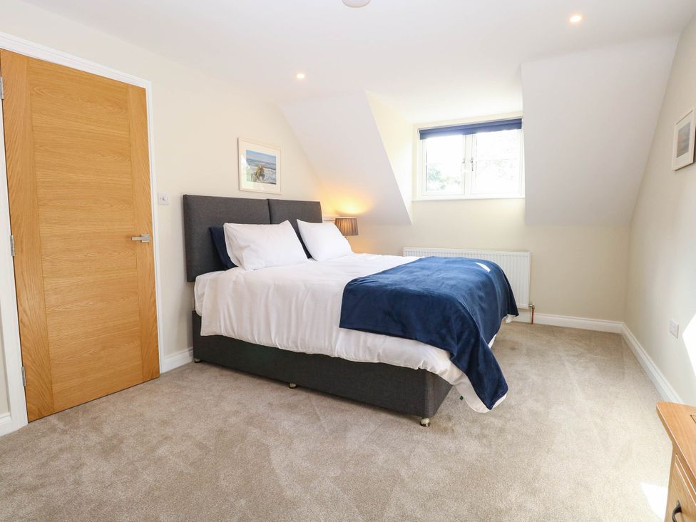 A bedroom with a bed and a window at Bramley Cottage in Worlingham