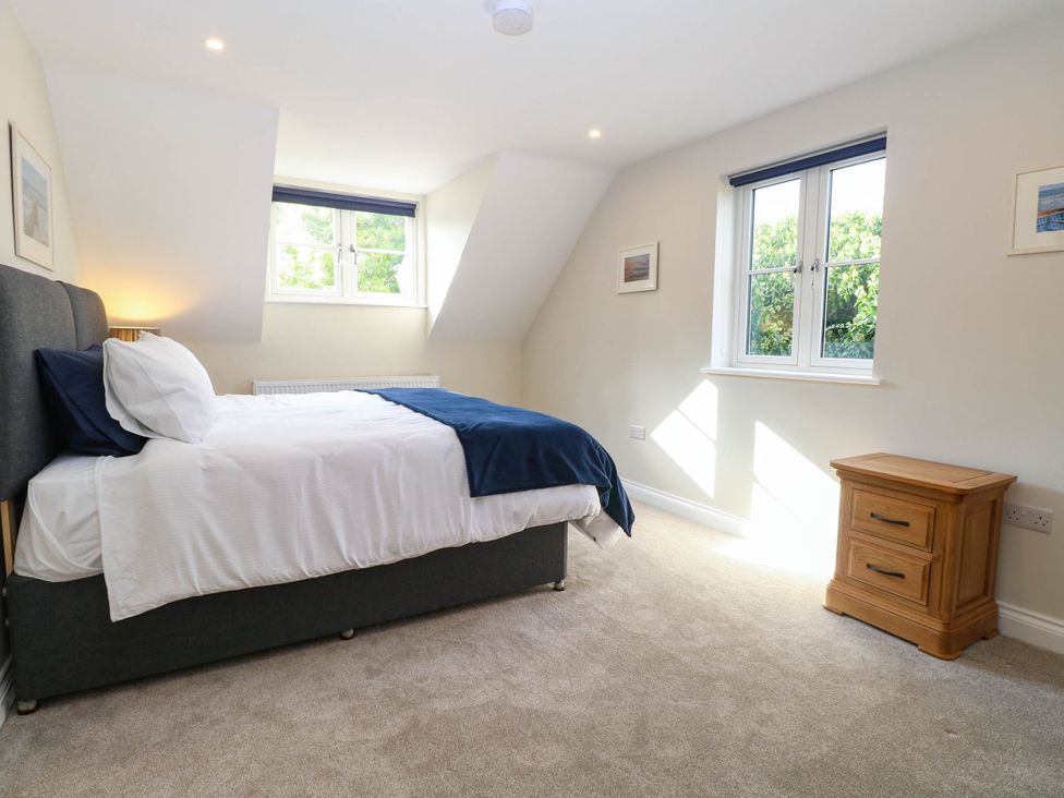 A bedroom with a bed and nightstand at Bramley Cottage in Worlingham