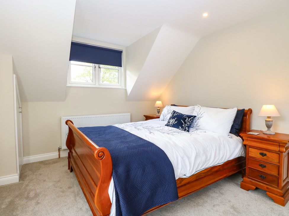 A bedroom with a bed and nightstand at Bramley Cottage in Worlingham