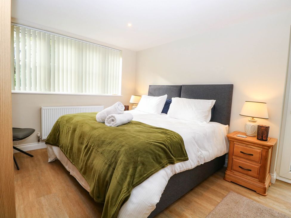 A bedroom with a double bed and bedside table at Bramley Cottage in Worlingham