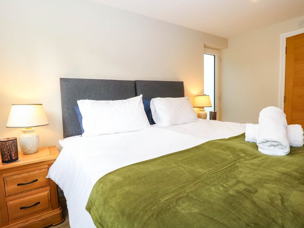 A bedroom with a bed and nightstand at Bramley Cottage in Worlingham