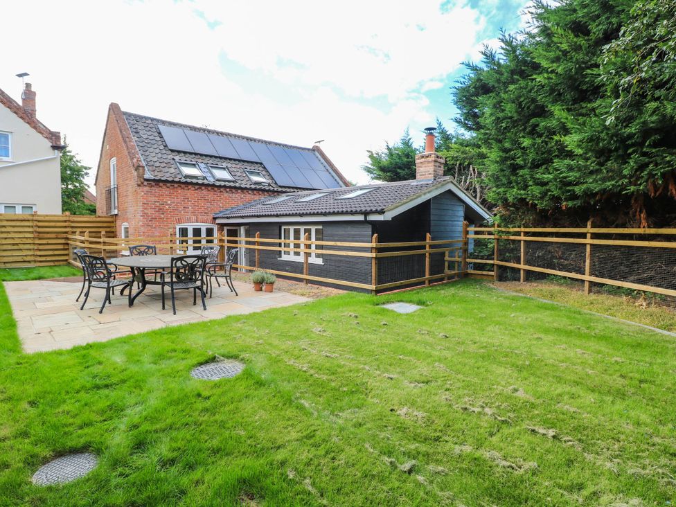 A garden with a patio table and chairs at Bramley Cottage in Worlingham