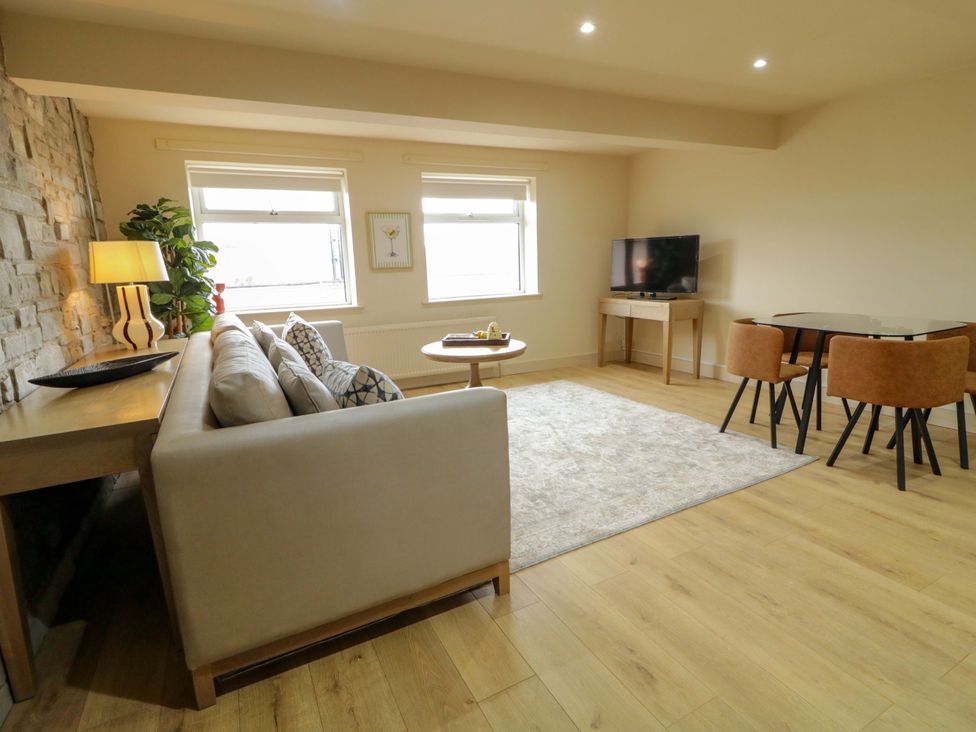 A living room with sofa, coffee table, and television at Apartment 1 Londonderry