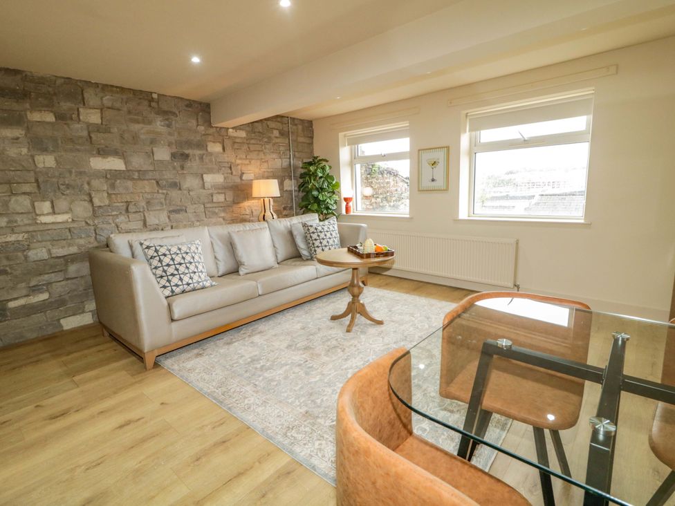 A living room with a sofa, coffee table, and plant at Apartment 1 in Londonderry