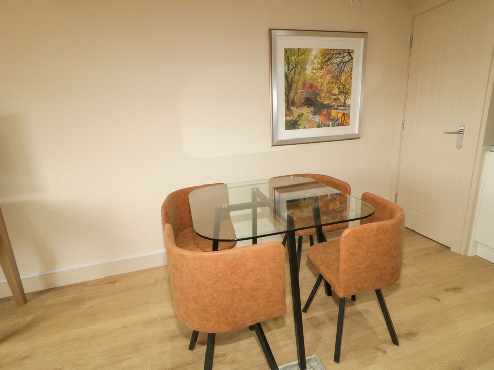 A dining room with a glass table and four chairs at Apartment 1 Londonderry