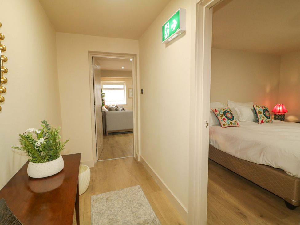A hallway with a table and exit sign at Apartment 1 in Londonderry