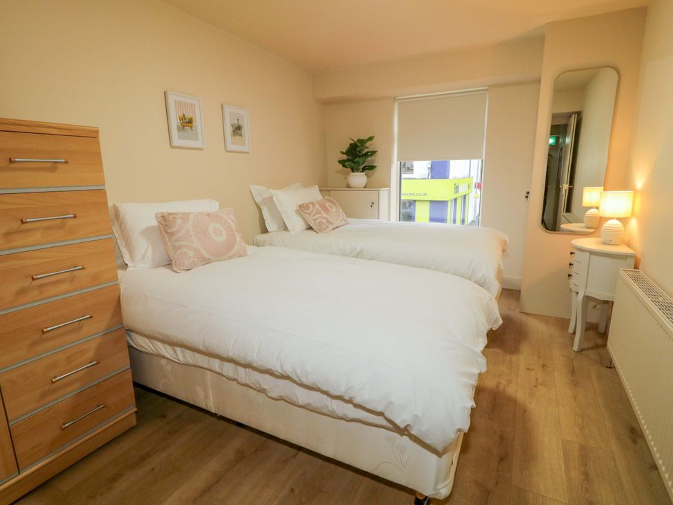 A bedroom with two beds and a dresser at Apartment 1 Londonderry