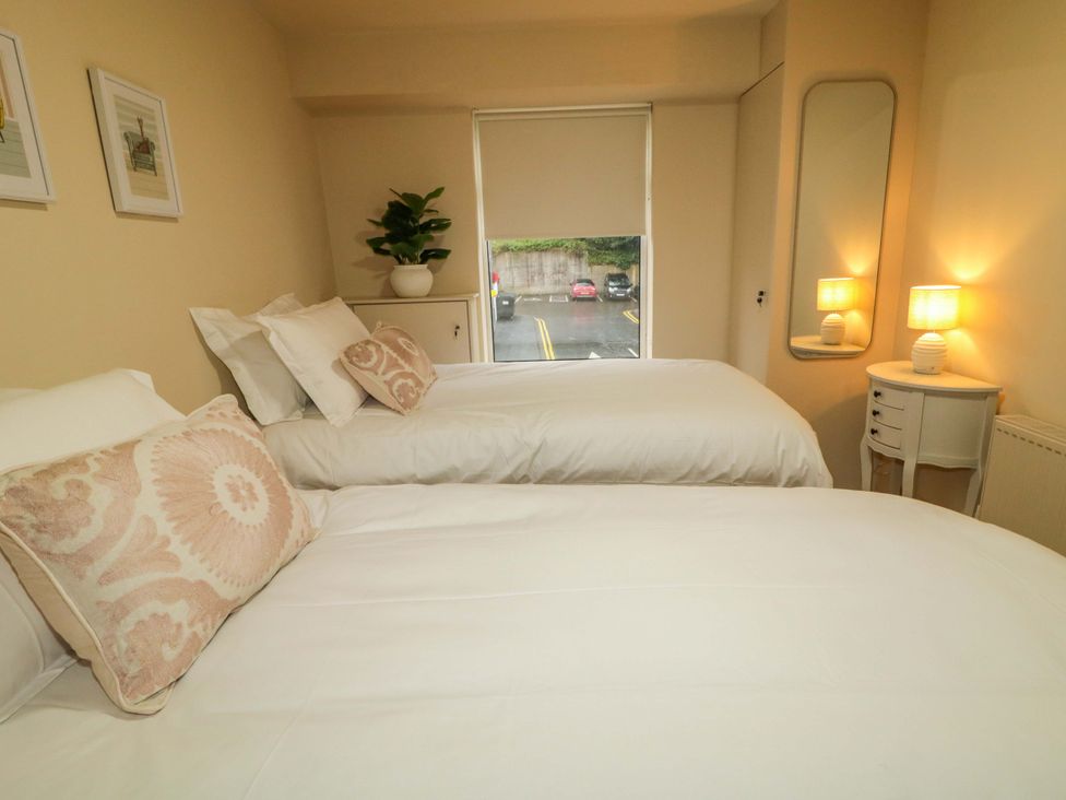 A bedroom with two beds and a plant on the bedside table at Apartment 1 Londonderry