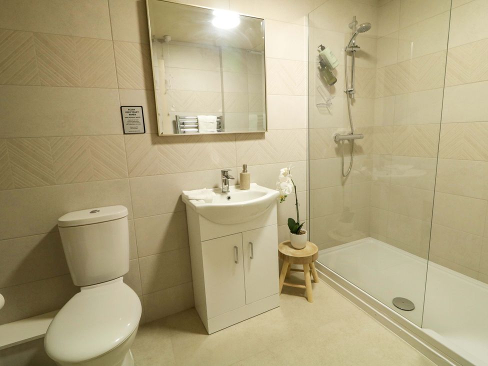 A bathroom with a shower, sink, and toilet at Apartment 1 in Londonderry