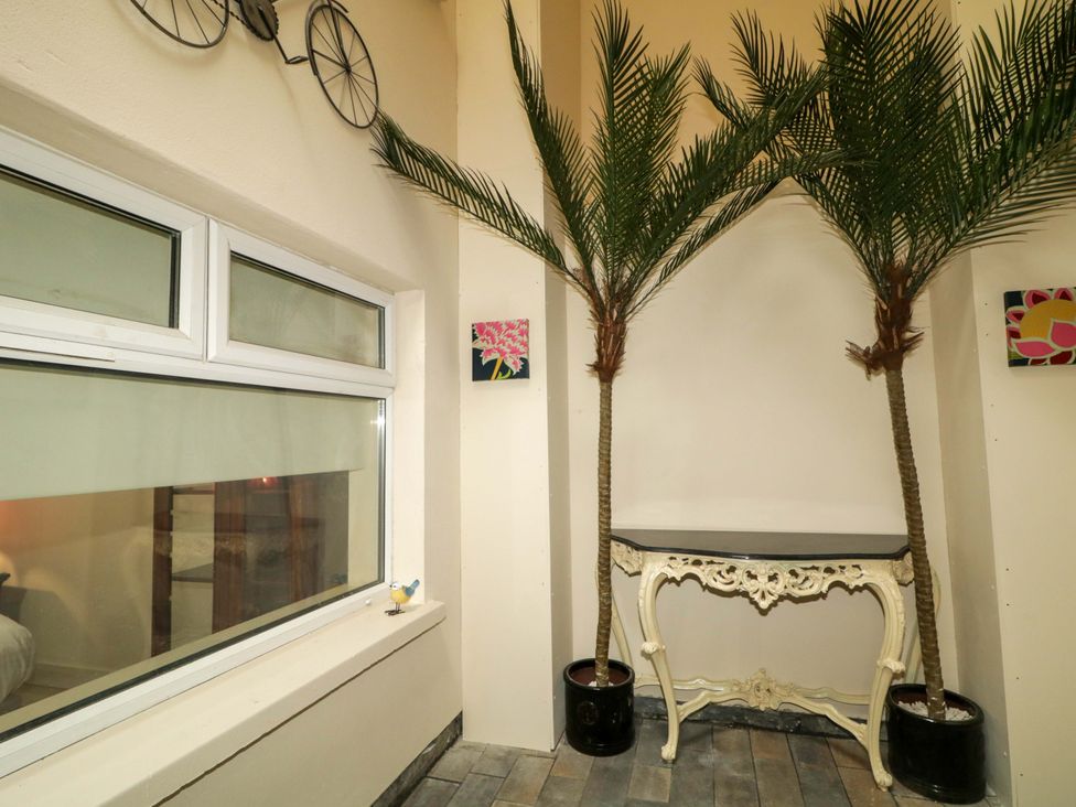 An indoor space with palm trees and a table at Apartment 1 in Londonderry