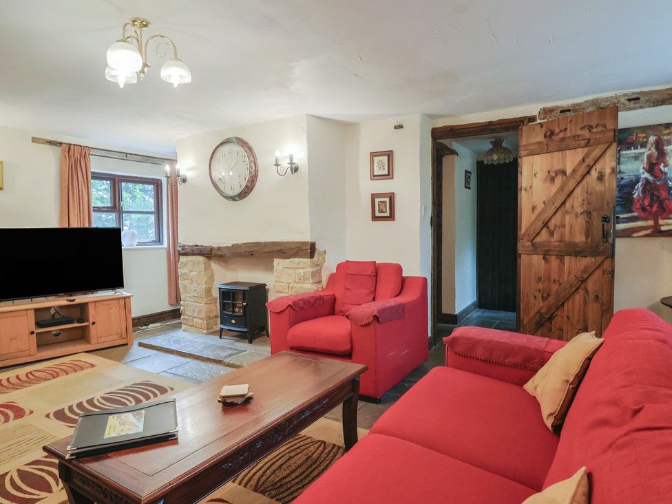 A living room with a fireplace and sofa at Cider House in Hawkchurch