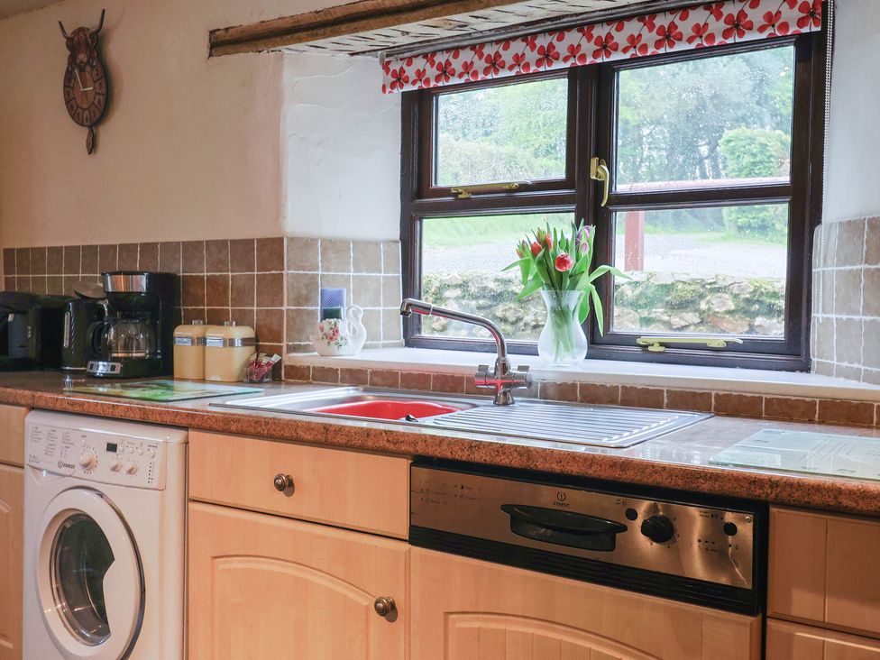 A kitchen with a washing machine and coffee maker at Cider House, Hawkchurch