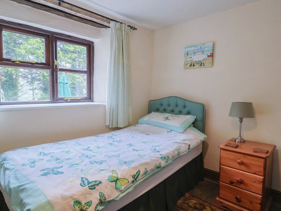 A bedroom with a bed and window at Cider House in Hawkchurch