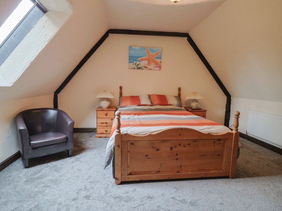A bedroom with a bed and nightstand at Cider House in Hawkchurch